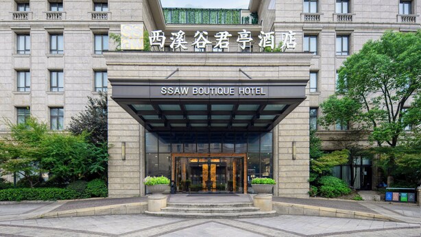 Entrada de un hotel con una marquesina de vidrio y un cartel que dice 'SSAW BOUTIQUE HOTEL'.