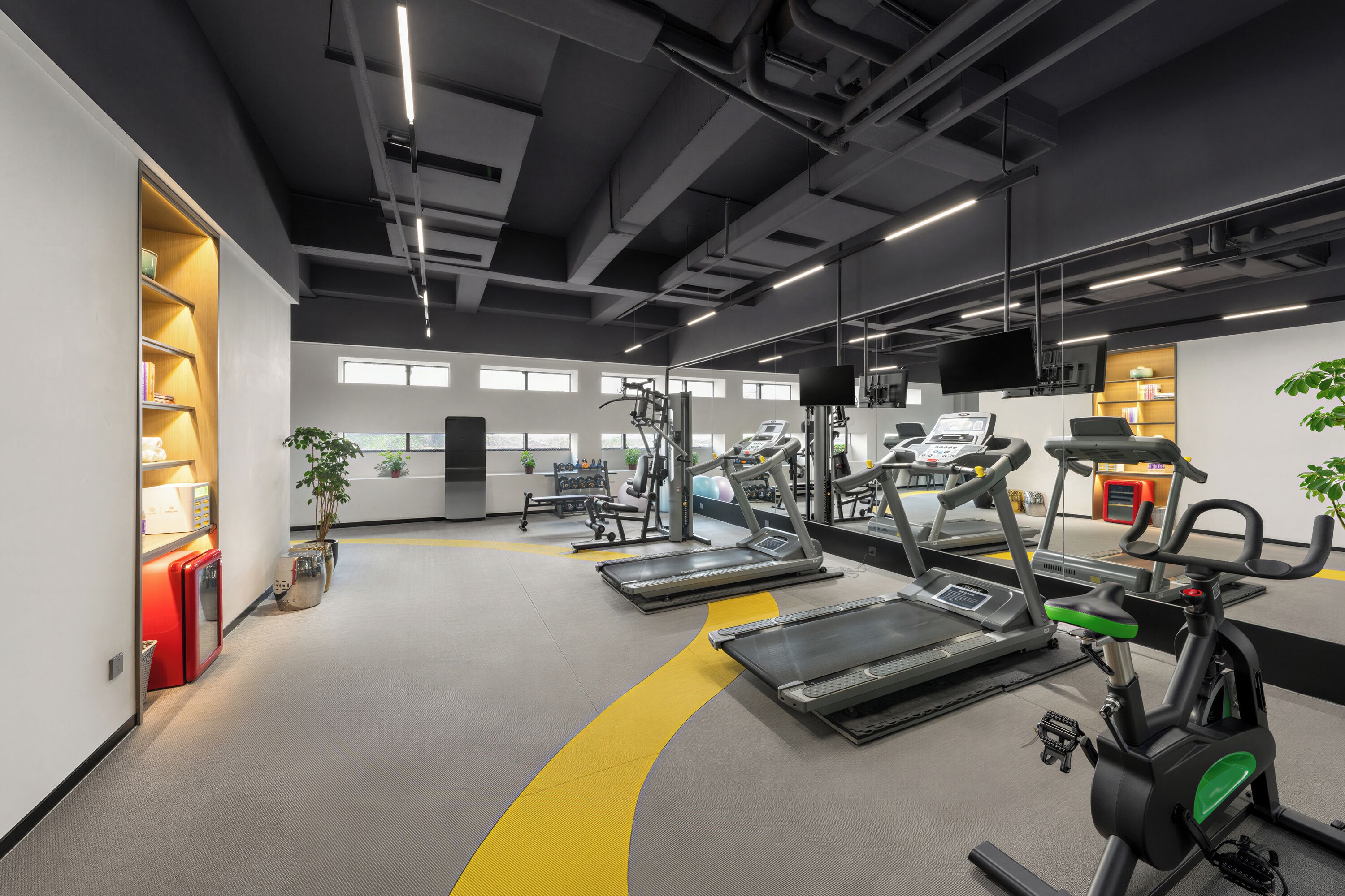 Ein modernes Fitnessstudio mit Laufbändern, Crosstrainern und Gewichtsmaschinen.