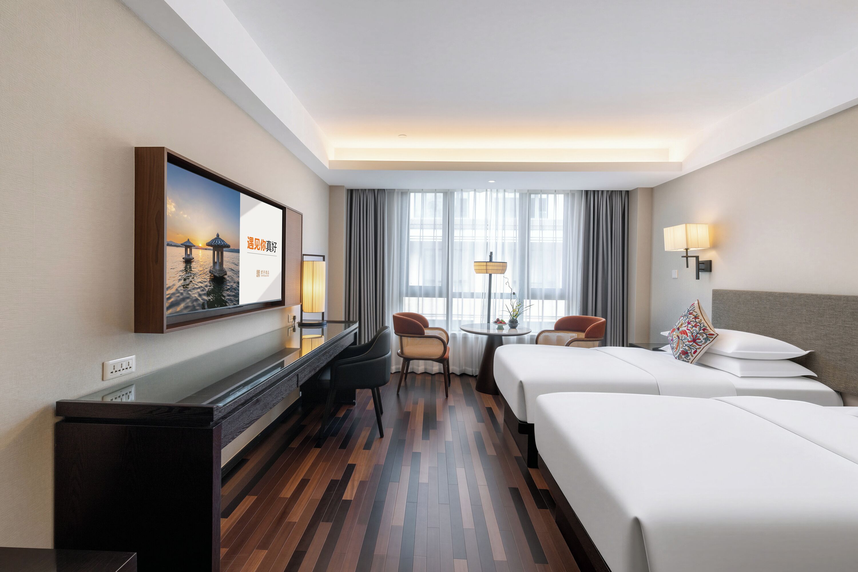 Une chambre d’hôtel équipée d’un lit, d’un bureau, d’une chaise, d’une table et d’un téléviseur.