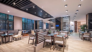 Un restaurante moderno con suelo de madera, asientos acolchados y diversas opciones de mesas.