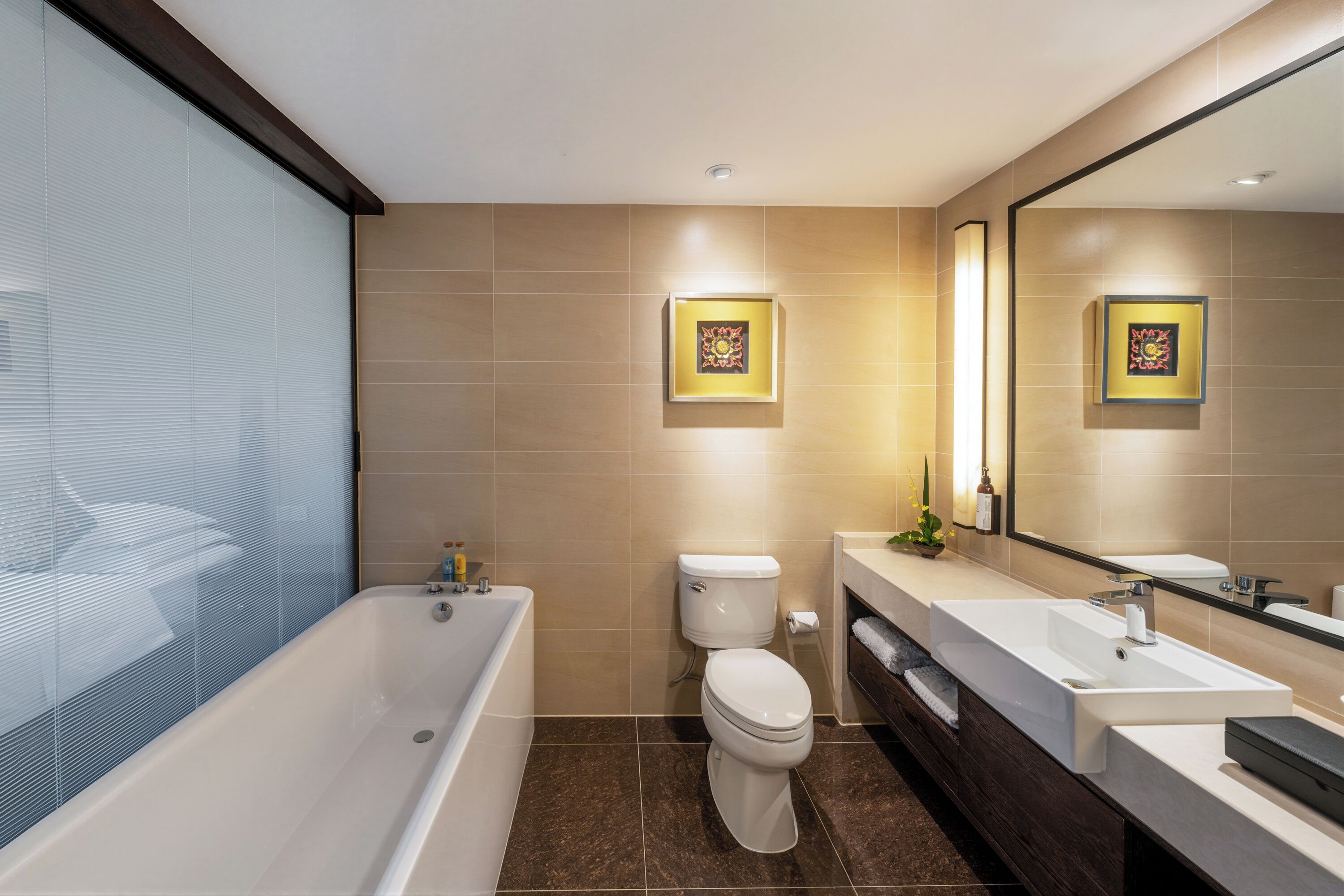 Une salle de bain moderne avec une baignoire, des toilettes et deux lavabos.