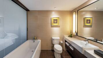 Une salle de bain moderne avec une baignoire, des toilettes et deux lavabos.