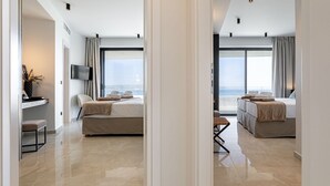 Ein modernes Hotelzimmer mit einem großen Bett, einem Schreibtisch und Blick aufs Meer.
