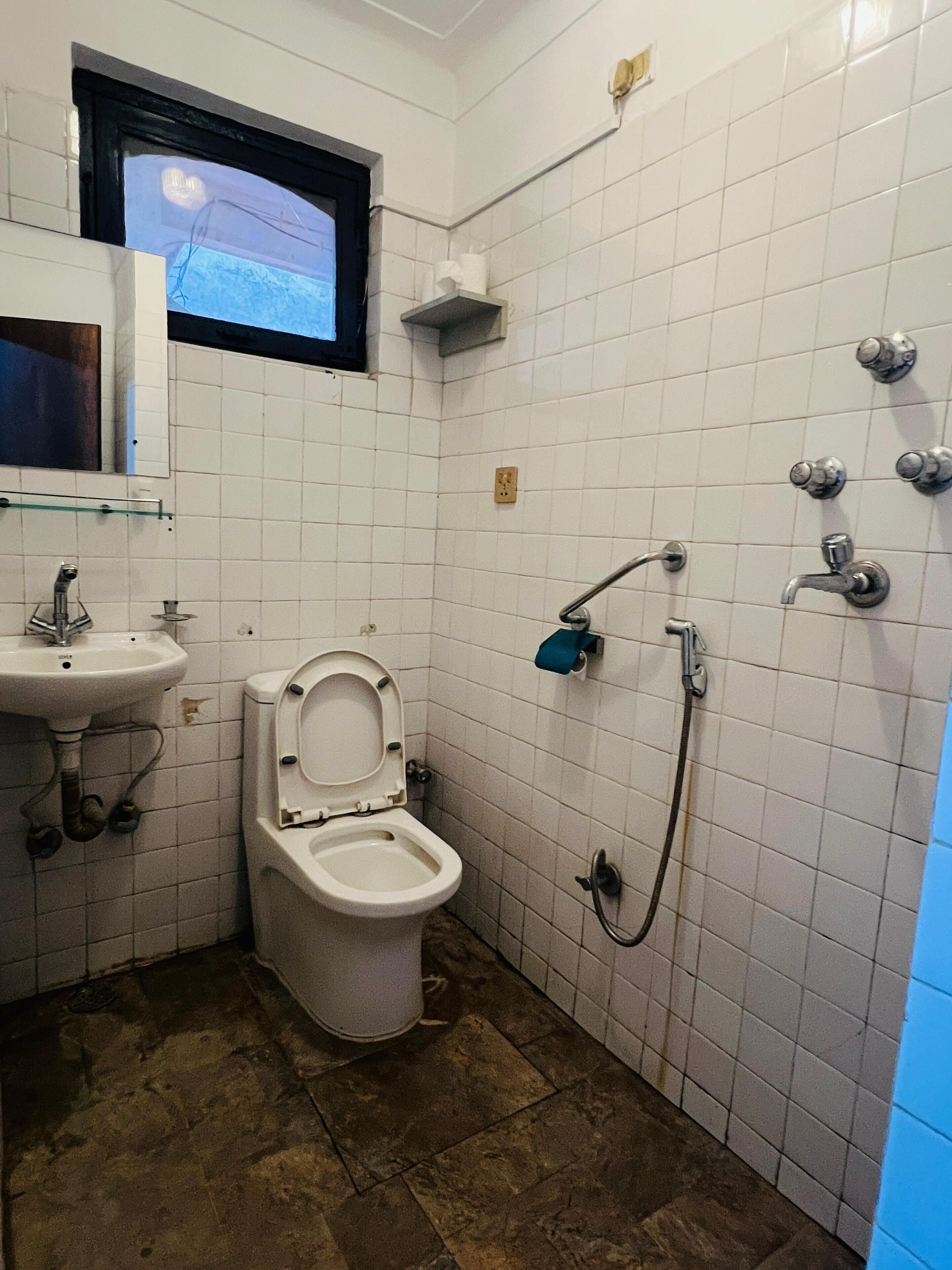Un baño pequeño con inodoro, lavamanos y ducha.