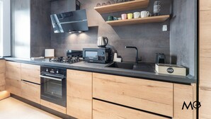 Eine moderne Küche mit eingebauten Geräten, Holzschränken und einer schwarzen Arbeitsplatte.