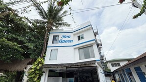 Un edificio di due piani con un cartello che riporta "Sea Queen".