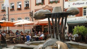 A public square with a fountain, outdoor seating, and buildings in the background. - Apartment 'Studio in Sankt Blasien' with Balcony and Wi-Fi (St Blasien)