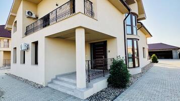 Une maison à deux étages avec un balcon, une allée et un petit jardin.
