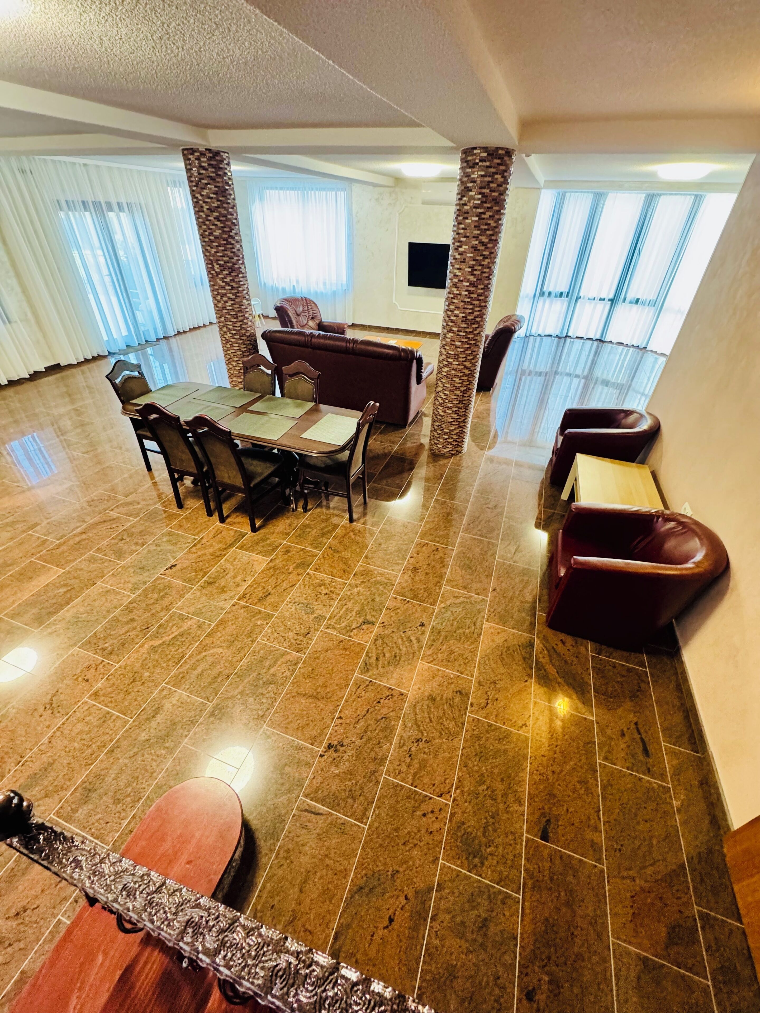 Amplia sala de estar con mesa de comedor, sillas, sofá y televisor.