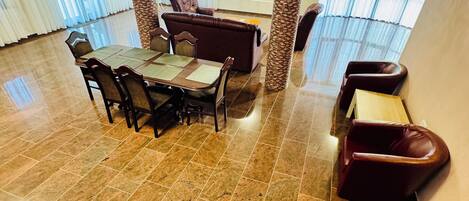 Amplia sala de estar con mesa de comedor, sillas, sofá y televisor.