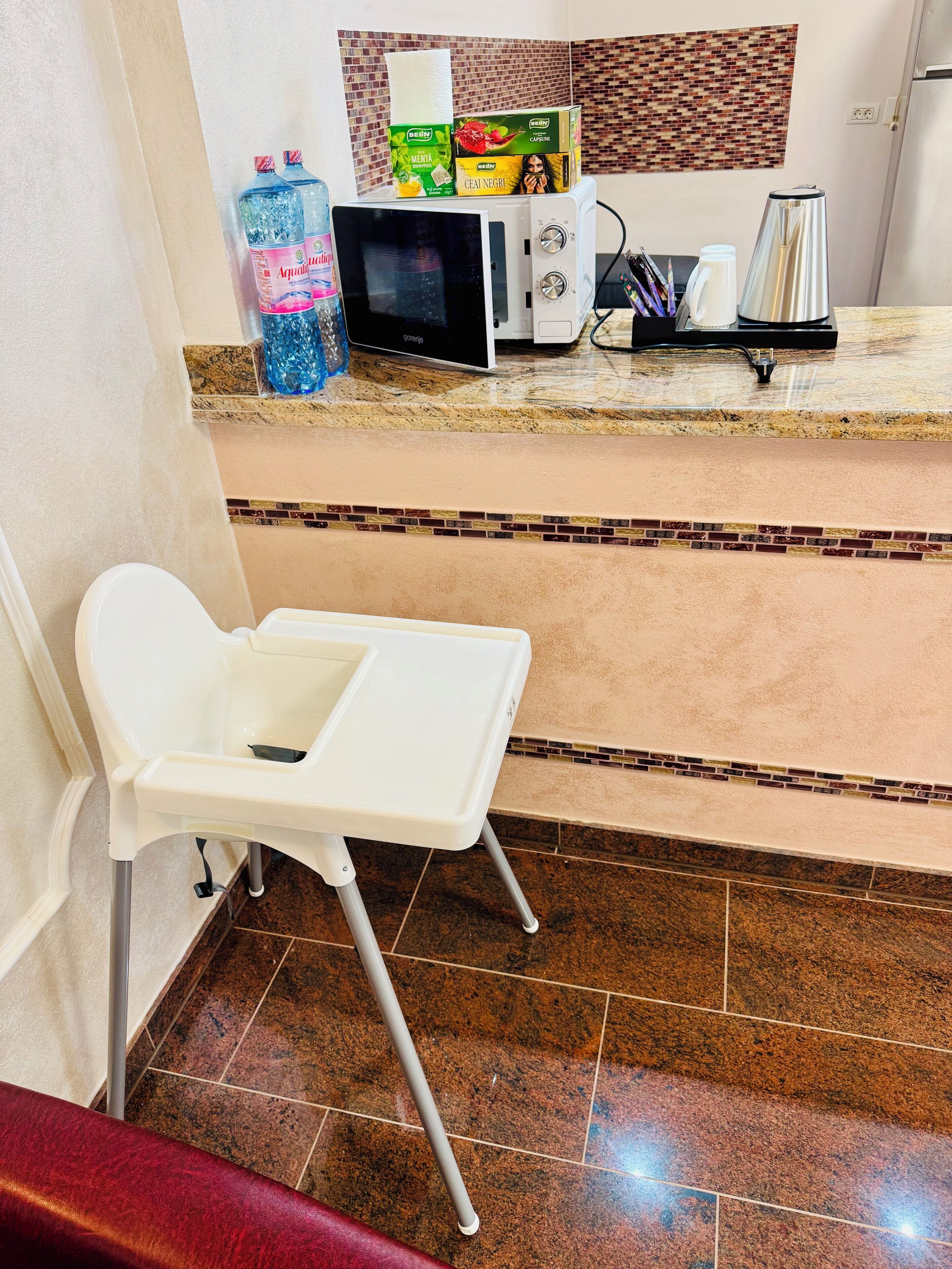A kitchen area with a microwave, a small table, and various items on the counter.