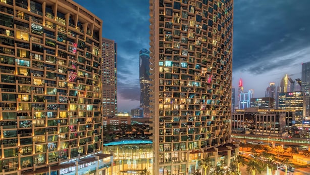 A high-rise building with multiple floors, large windows, and a well-lit facade. - LUX  The Address Opera Downtown Suite (Dubai)