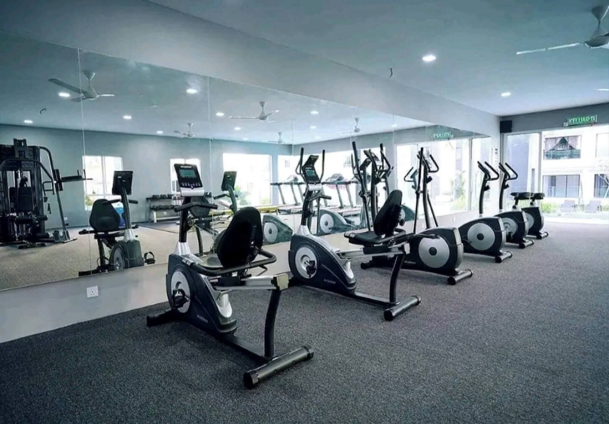 A gym with treadmills, elliptical machines, and weight equipment.
