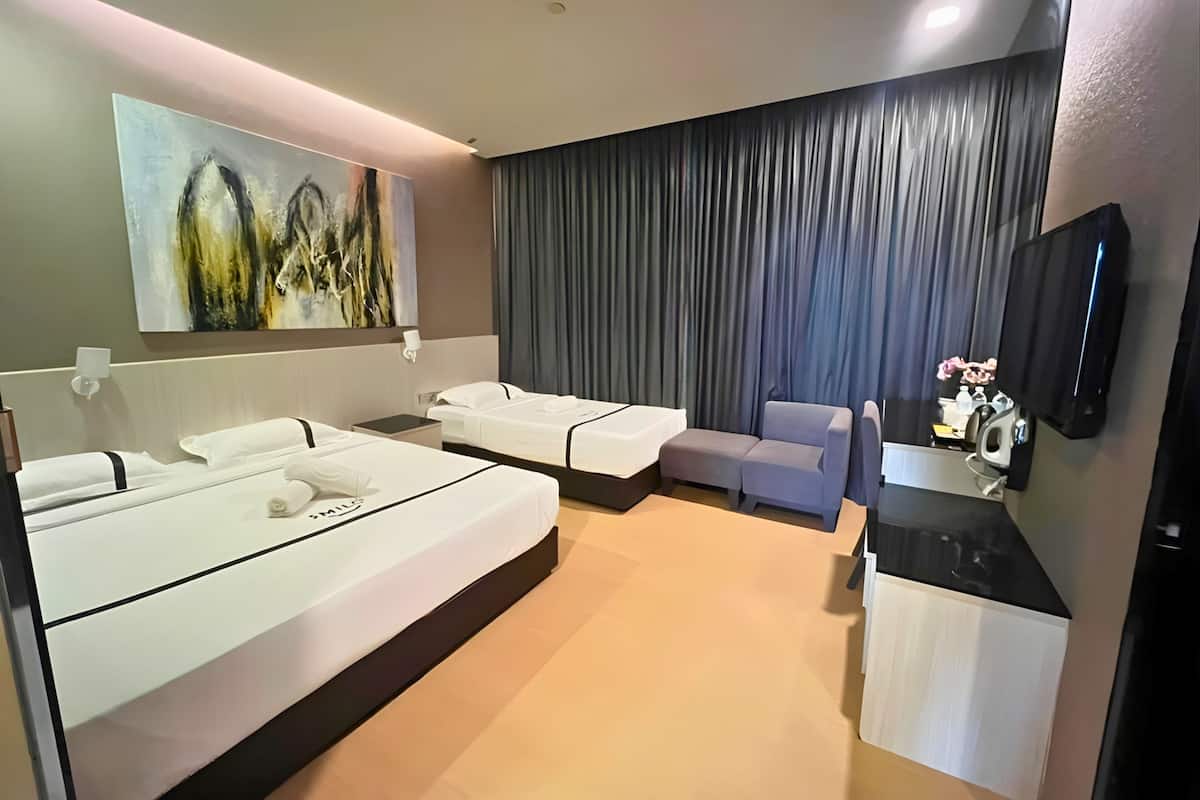 Een moderne hotelkamer met een groot bed, een kleiner bed, een slaapbank, een televisie en een schilderij aan de muur.