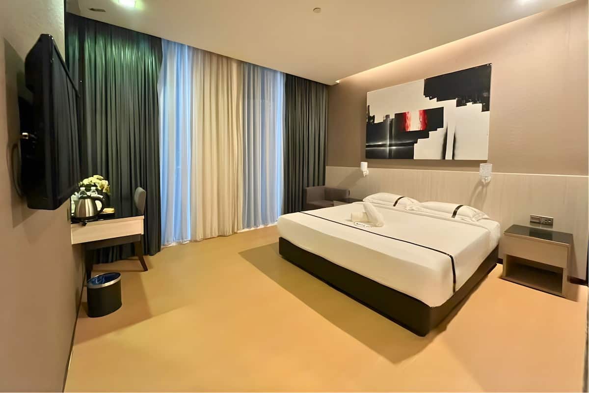 Een moderne hotelkamer met een groot bed, een televisie, een nachtkastje en een wanddecoratie.