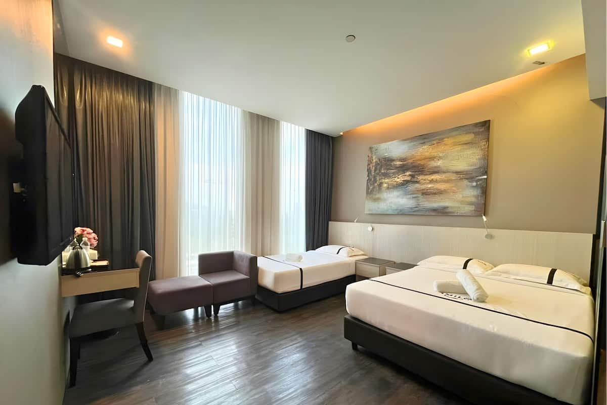 Een hotelkamer met een bed, een bureau, een stoel, een televisie en een schilderij aan de muur.