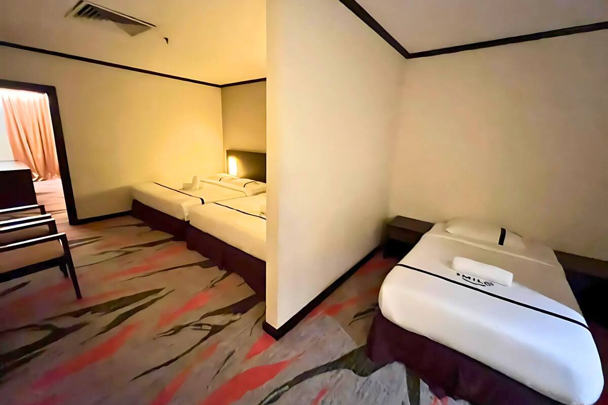Ein Hotelzimmer mit zwei Betten, einem Schreibtisch und einem Stuhl.