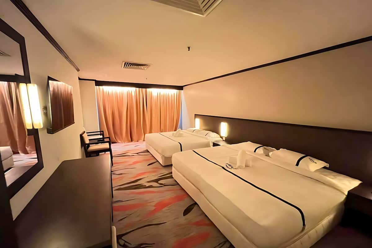 Ein Hotelzimmer mit zwei Betten, einem Schreibtisch und Blick nach außen.