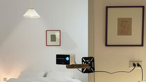 A bedroom with a bed, a projector mounted on the wall, and a framed picture on the wall. - Cozy studio with washing machine & dryer in the heart of Hà Nội (Hà Nội)
