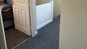 Une chambre à coucher avec un lit, une porte et un luminaire au plafond.