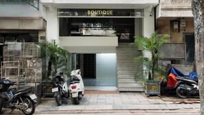 Een gebouw met een boetiek genaamd 'BOUTIQUE' en een winkel met de naam 'HANDI BLISS' op de begane grond.