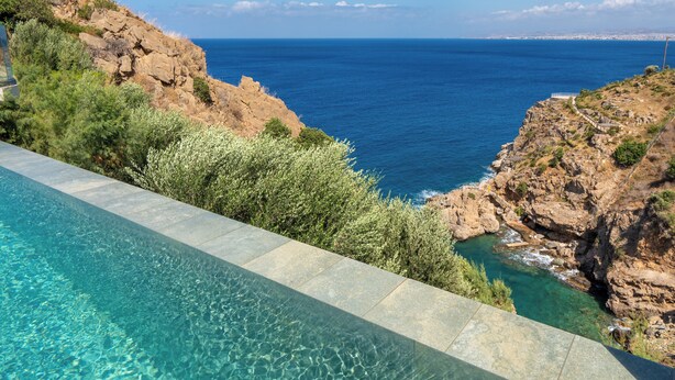 A pool with clear water, a rocky cliff, and a view of the ocean. - Soluna Forte Sea Living Suites (Malevizi)