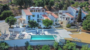 A modern resort with a swimming pool, outdoor seating, and a hillside view. - Soluna Forte Sea Living Suites (Malevizi)
