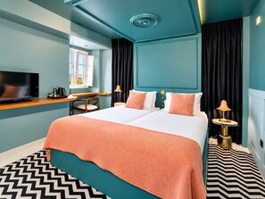 Una camera d'hotel moderna con un letto grande, una scrivania, una televisione e vista sull'esterno.