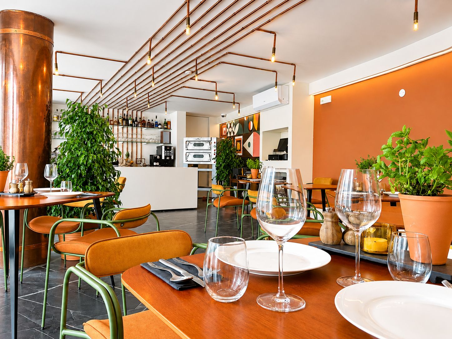 A restaurant interior with a bar area, seating, and a kitchen in the background.