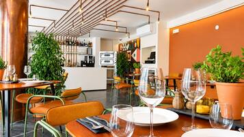 A restaurant interior with a bar area, seating, and a kitchen in the background.