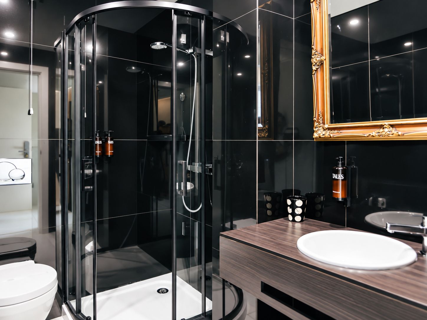 A modern bathroom with a glass-enclosed shower, a wooden vanity with a sink, and a large mirror.