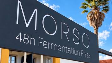 Un edificio con un letrero que dice 'MORSO 48h Fermentation Pizza'.