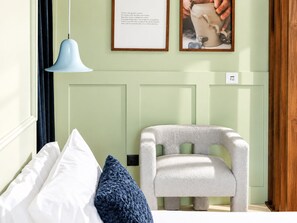A room with a bed, a chair, a pendant light, and two framed pictures on the wall. - &Tales Hotel (Óbidos)
