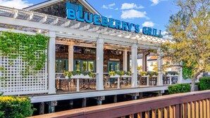 Un restaurant anomenat 'Blueberry's Grill' amb terrassa exterior i una zona de pati coberta.