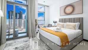 Een moderne hotelkamer met een groot bed, uitzicht op de stad en een eigentijds kunstwerk aan de muur.