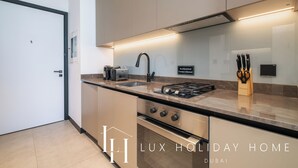 Een moderne keuken met een gasfornuis, spoelbak en roestvrijstalen apparatuur.