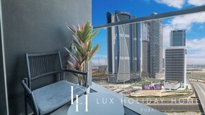 Een balkon met uitzicht op de skyline van Dubai, met moderne wolkenkrabbers.