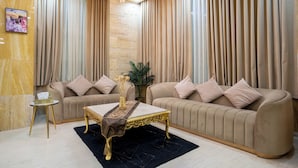 Un salon avec deux canapés, une table basse et un lustre.