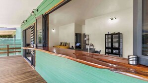Una cocina moderna con encimera de madera, pileta integrada y vista al mar.