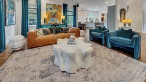 A spacious living room with a brown sofa, blue armchairs, and a unique white coffee table. - Modern eclectic 4BR, 3BA home in the heart of Inman Park. (Atlanta)