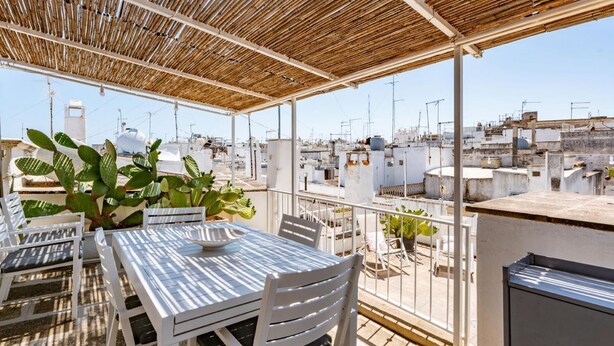 A rooftop terrace with a table and chairs, potted plants, and a view of the cityscape. - Dimora Oliver by Rentbeat  (Ostuni)