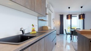 A modern kitchen with a central island, built-in appliances, and a dining area with a view.