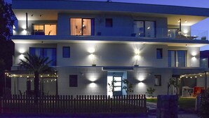 A modern two-story building with multiple illuminated windows and balconies. - Stunning apartment in Drenje with WiFi (Drenje)