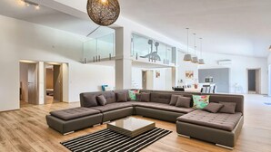 A spacious living area with a large sectional sofa, a glass coffee table, and a modern chandelier. - Beautiful home in Rovinjsko selo (Rovinjsko selo)