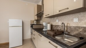 A modern kitchen with a refrigerator, coffee maker, and a sink. - Beautiful apartment in Palit with WiFi (Palit)