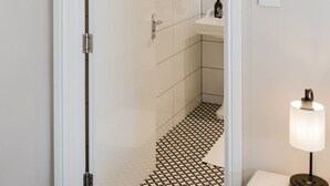 A modern bathroom with a shower, a sink, and a mirror. - Grace`s Guesthouse Room 2 (Tring)