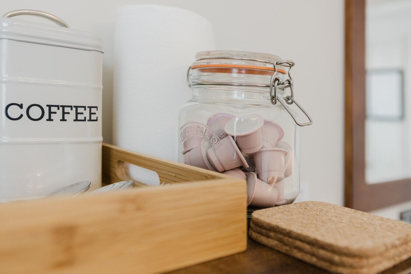 Een keukentrap met een koffiepot, een koffiebus en een houten dienblad.