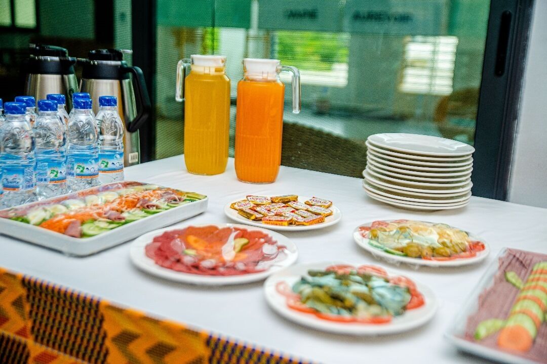 Ein reichhaltiges Buffet mit verschiedenen Speisen, Wasserflaschen und Saftkaraffen.