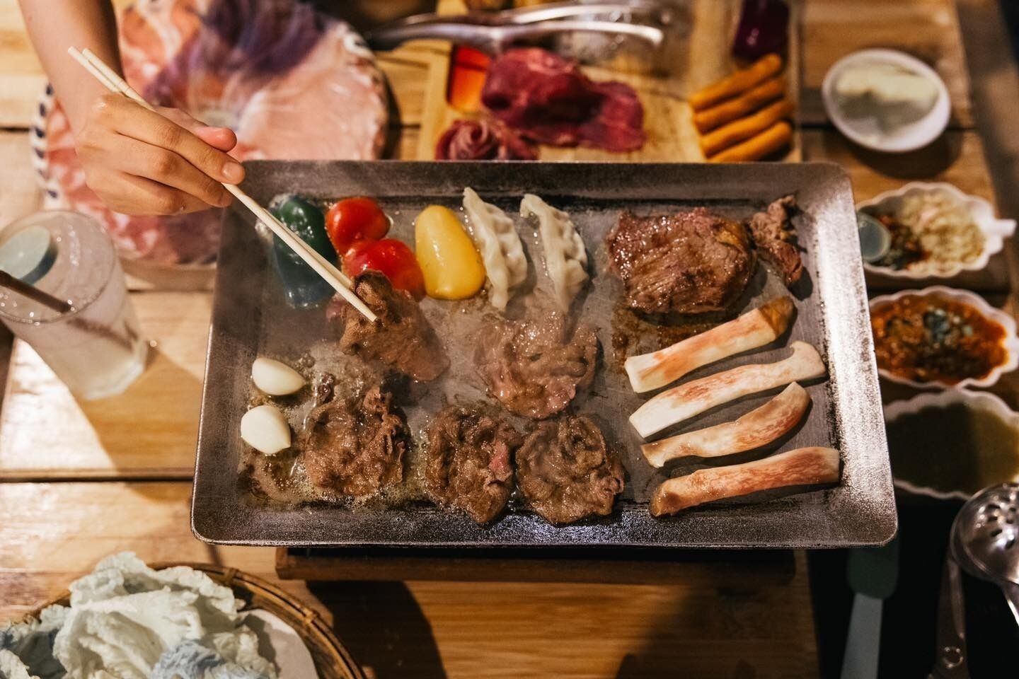 A hot plate with various meats and vegetables.