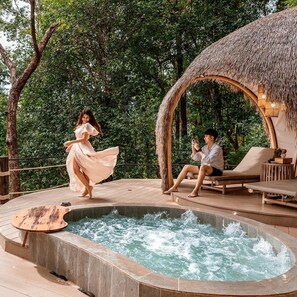 A hot tub with a wooden deck, surrounded by lush greenery. - Lannawild Chiang Mai (Mae On)